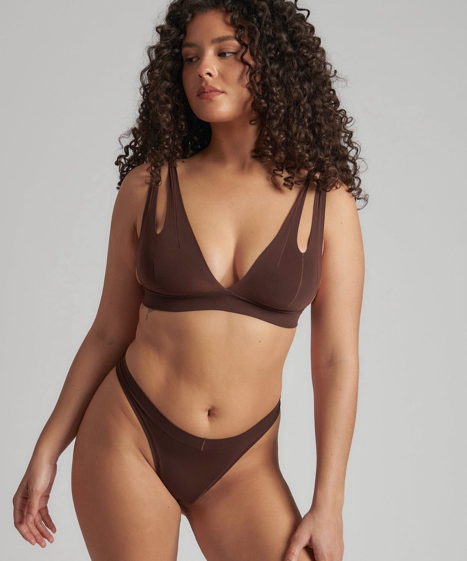 A brown-colored Tee System, designed with multiple strap options, worn by a model.