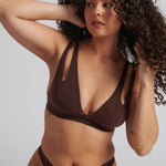 A brown-colored Tee System, designed with multiple strap options, worn by a model.