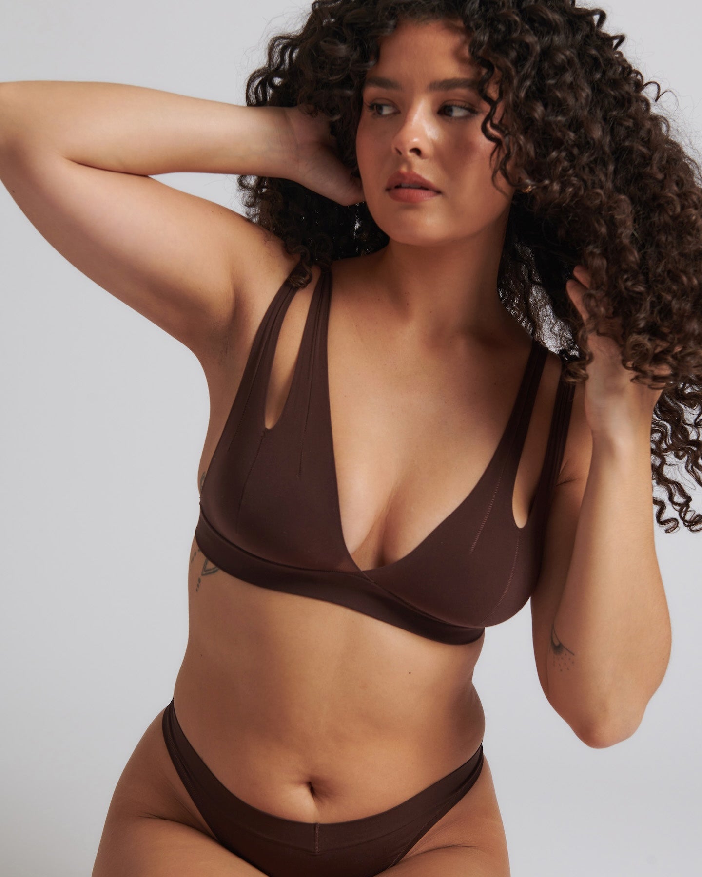 A brown-colored Tee System, designed with multiple strap options, worn by a model.
