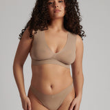 A person wearing a beige fuller coverage bra.