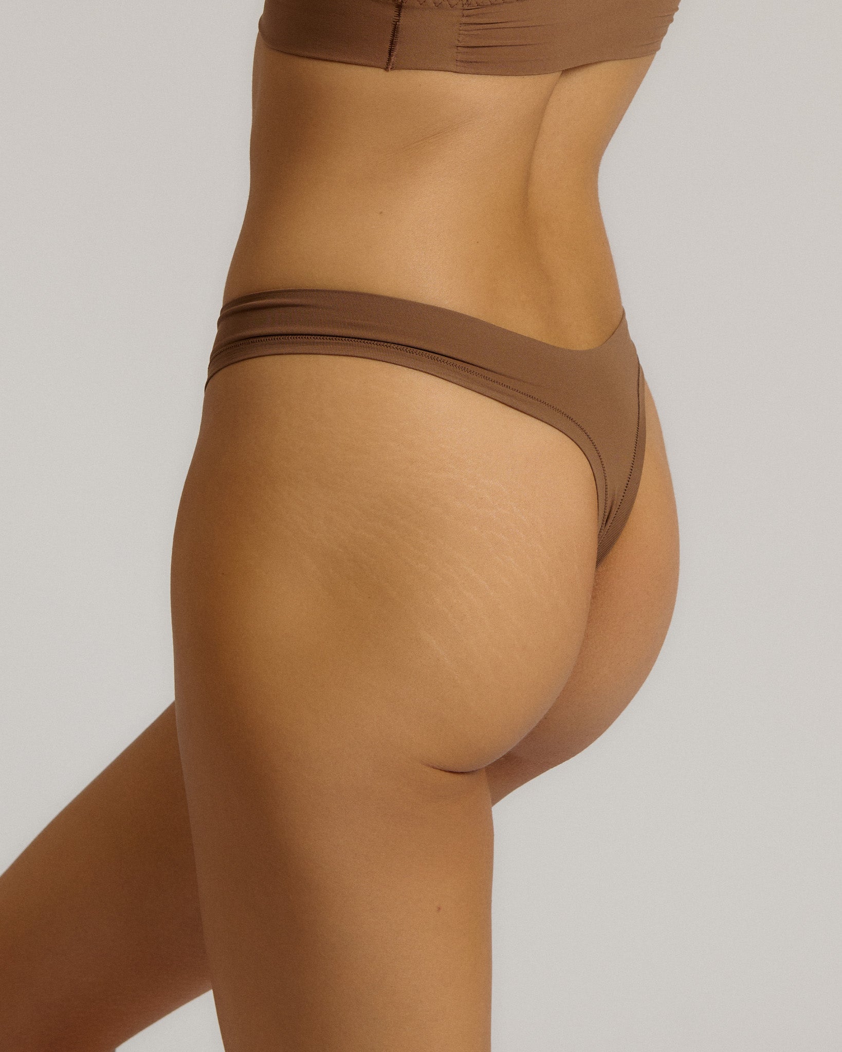 Woman standing wearing the Thong in brownz