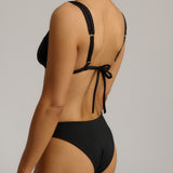 Black bikini with tie-back design on a neutral background