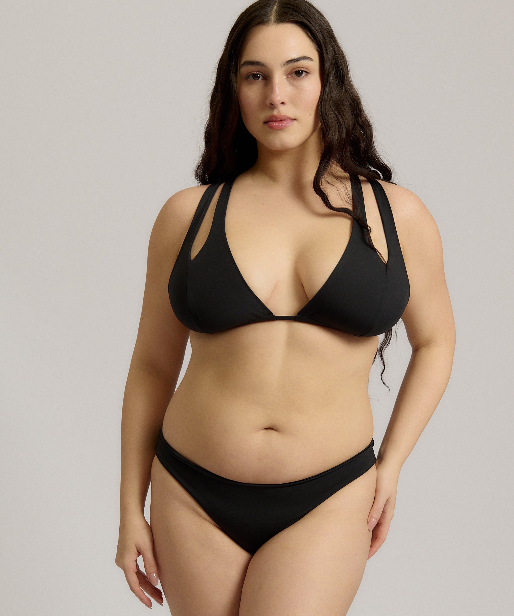 Woman wearing a black bikini against a plain background