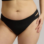Person wearing black high-waisted bikini bottoms on a neutral background