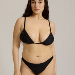 Black triangle bra worn by a model on a plain background