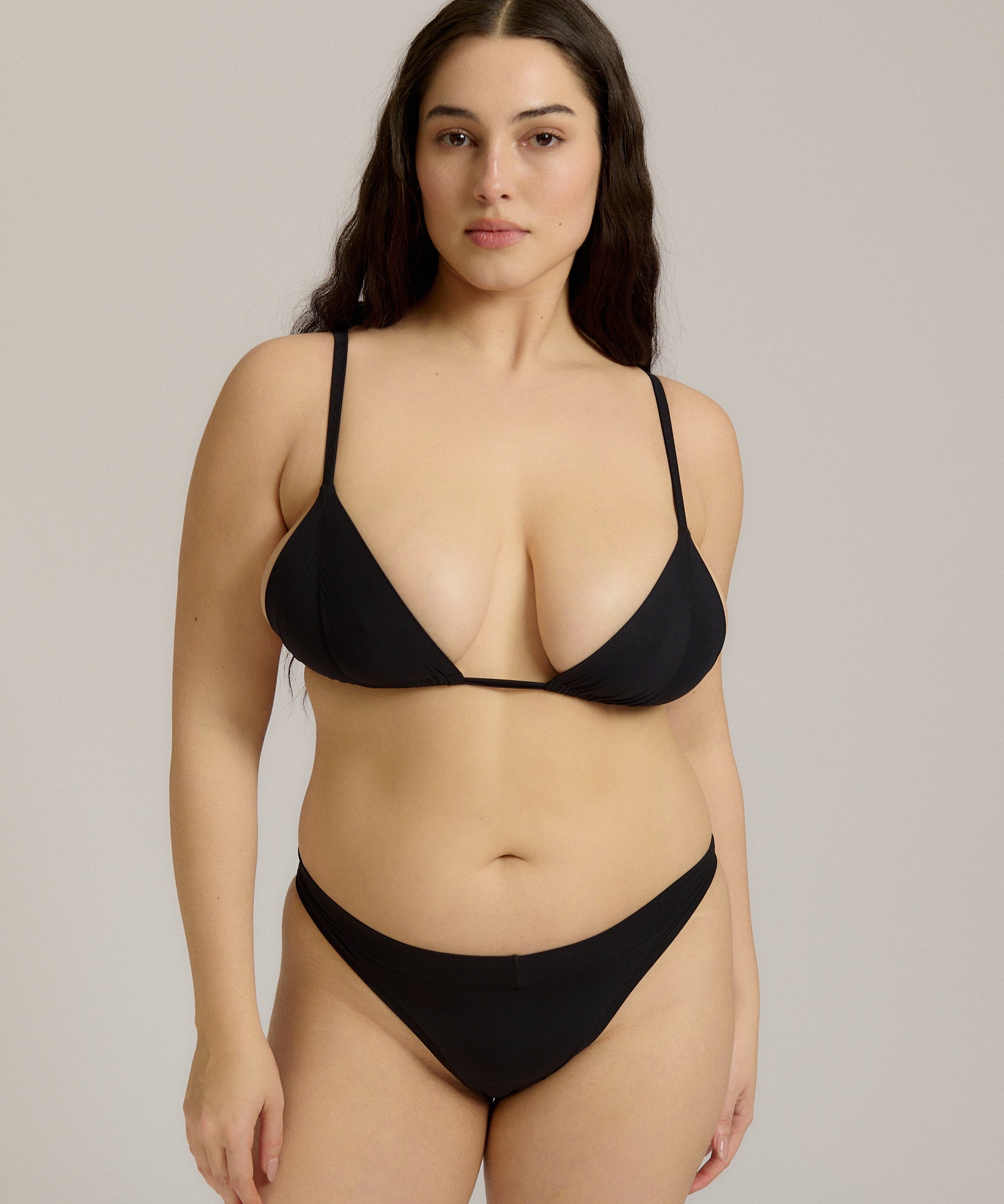 Black triangle bra worn by a model on a plain background
