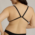 Black triangle bra worn by a model on a plain background