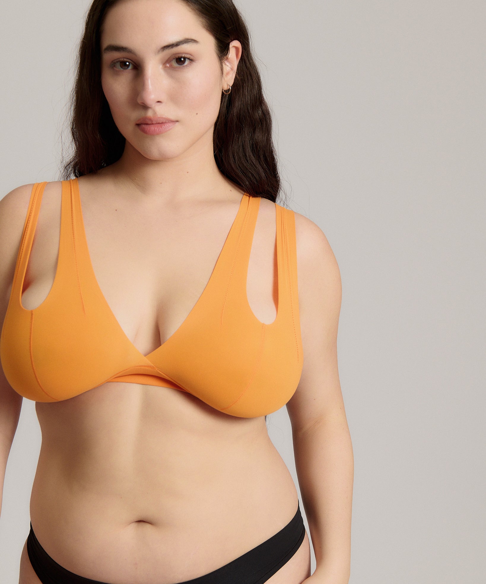 person wearing a tangerine tee system on a plain background