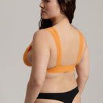 person wearing a tangerine tee system on a plain background