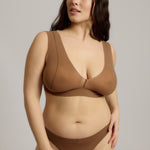 Woman wearing a brown bra against a plain background