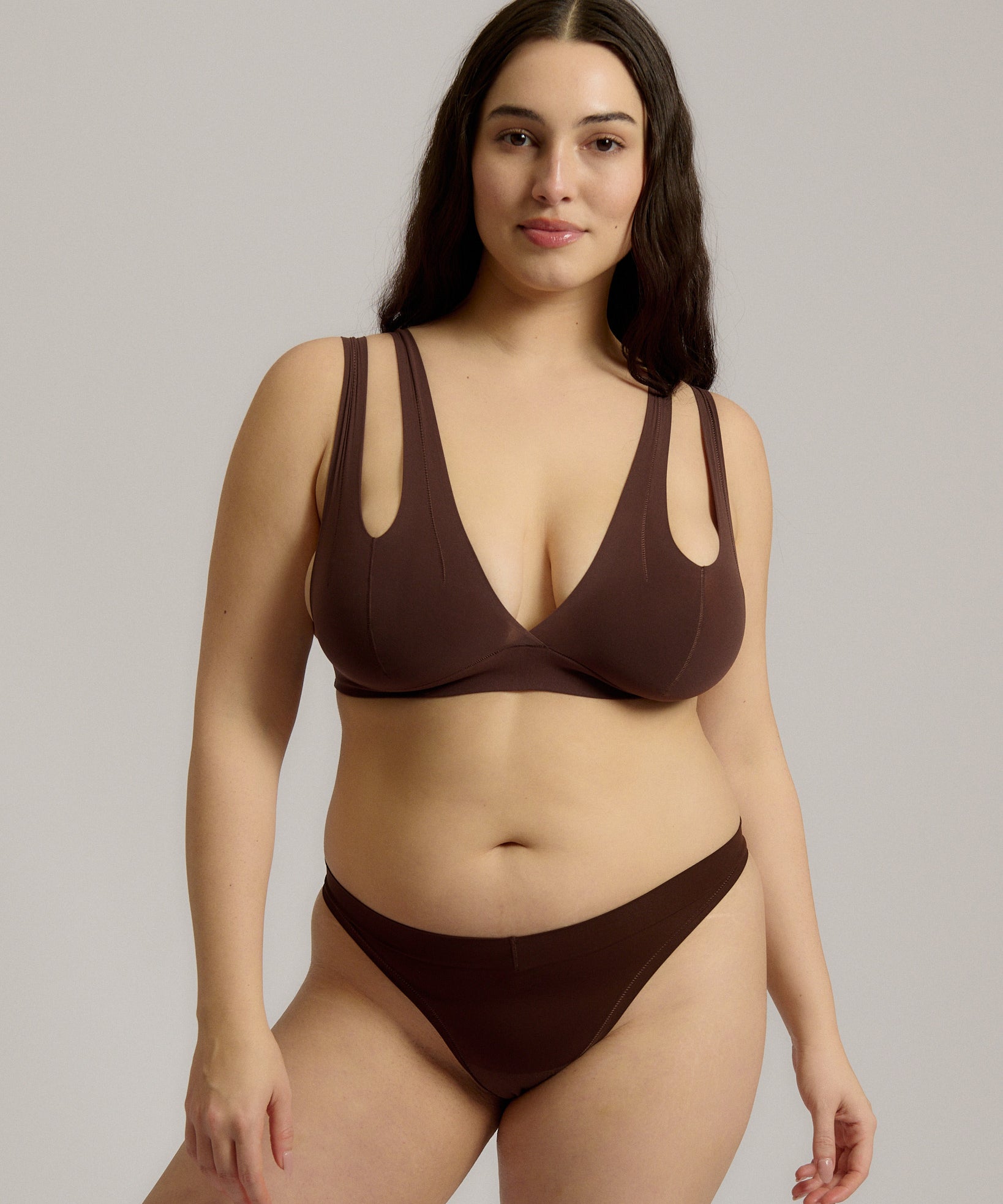 A brown-colored Tee System, designed with multiple strap options, worn by a model.