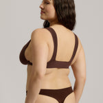 A brown-colored Tee System, designed with multiple strap options, worn by a model.