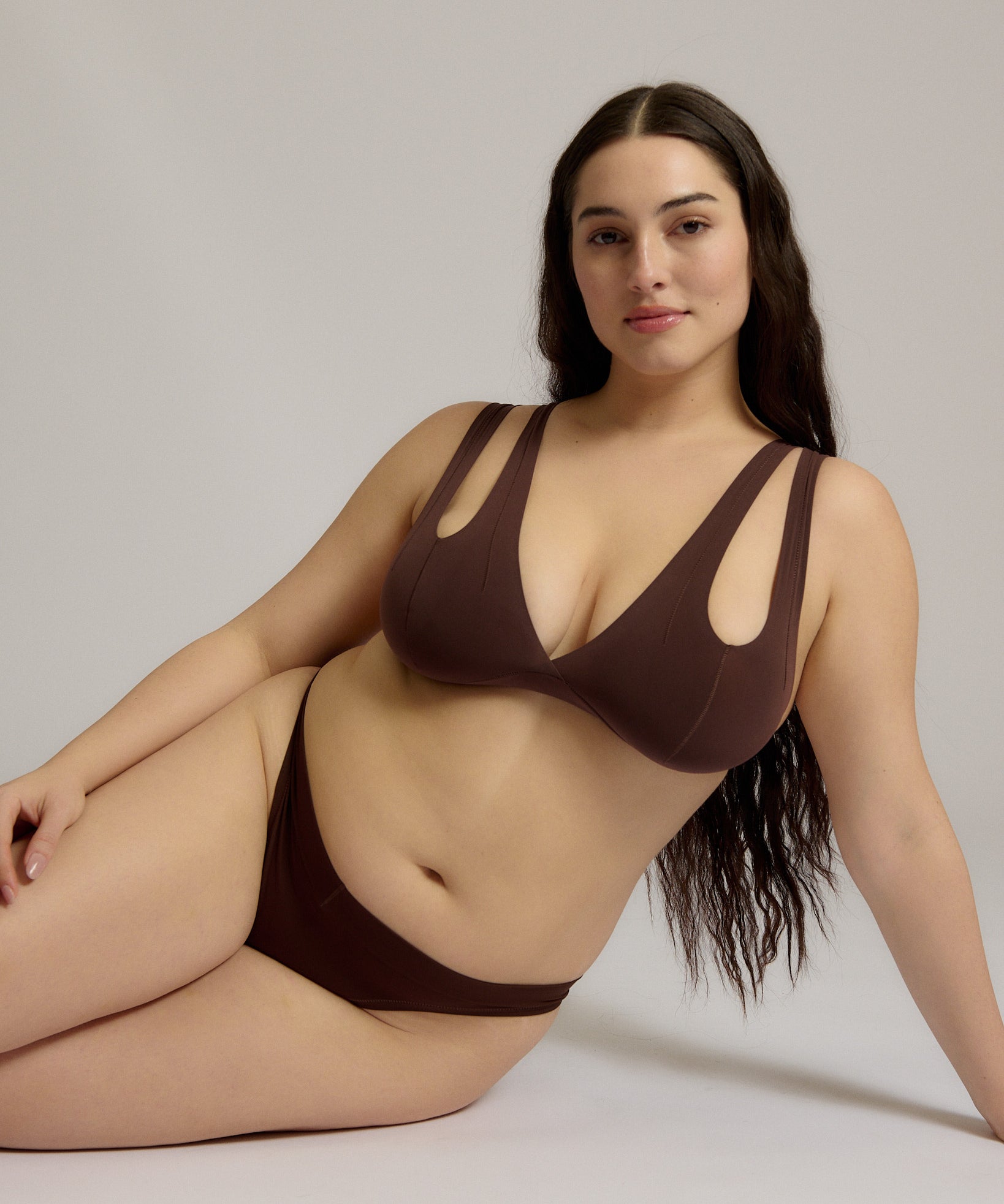 A brown-colored Tee System, designed with multiple strap options, worn by a model.