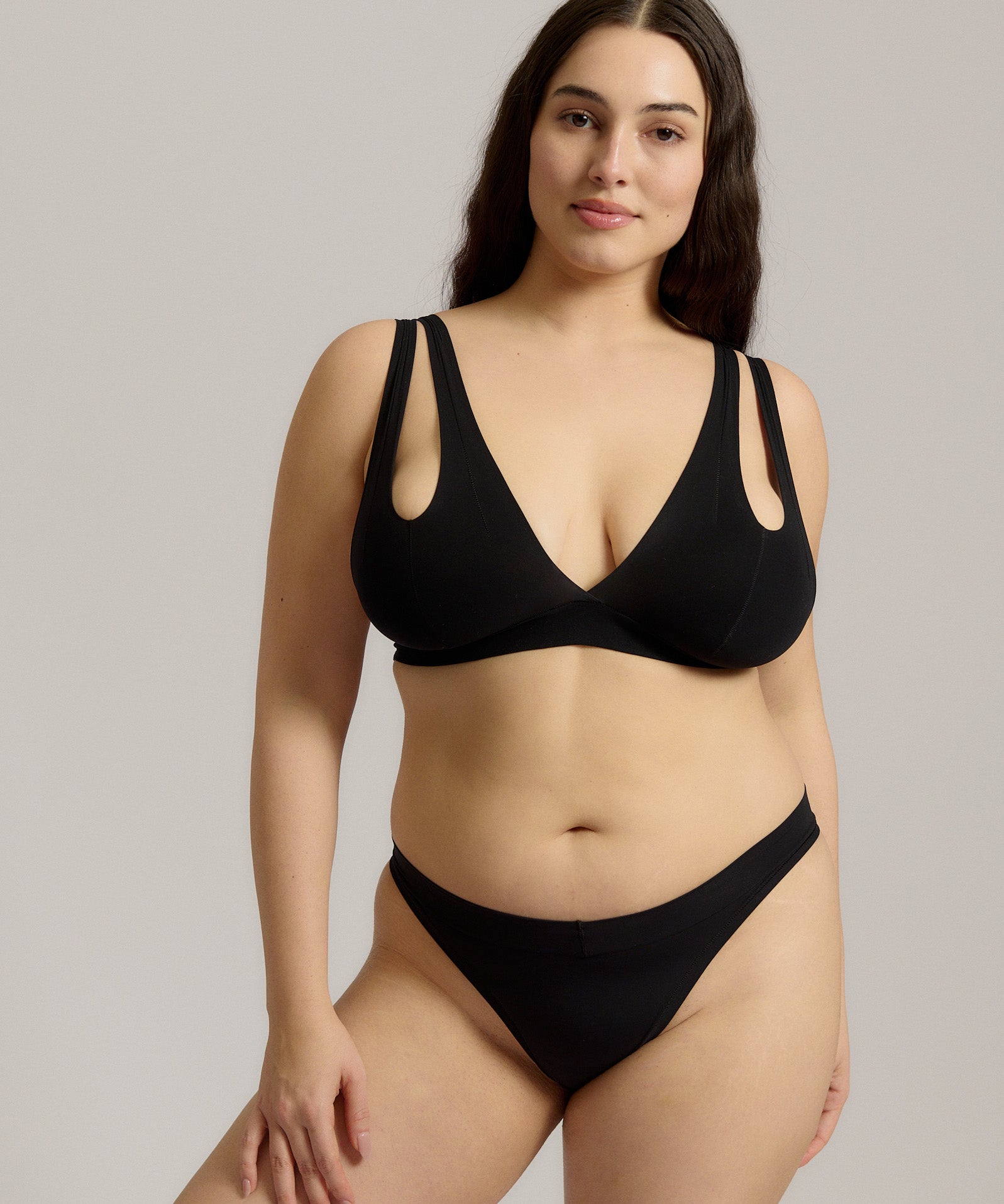 Woman wearing black tee system on plain background