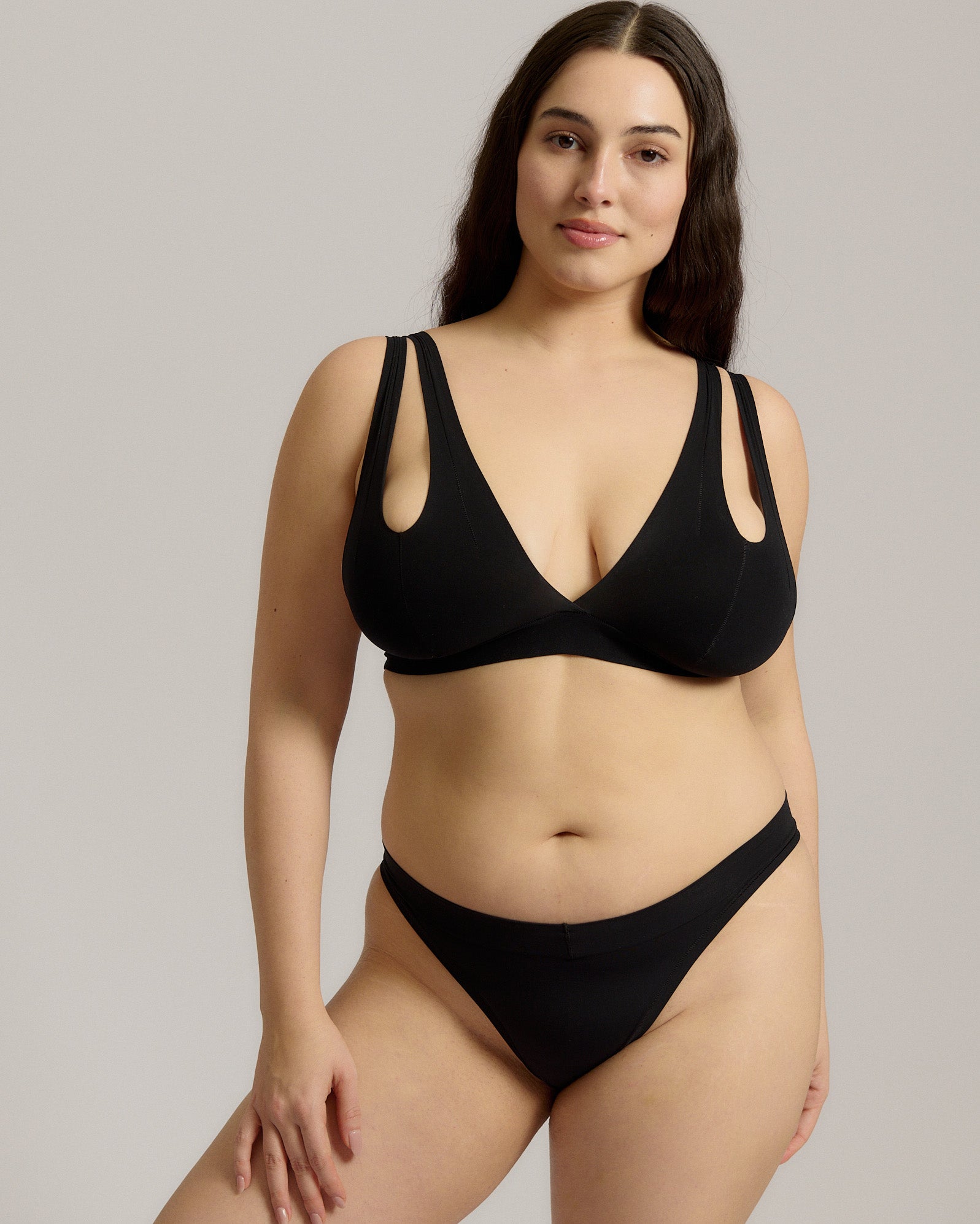 Woman wearing black tee system on plain background