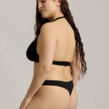 Black halter system worn by a person on a plain background