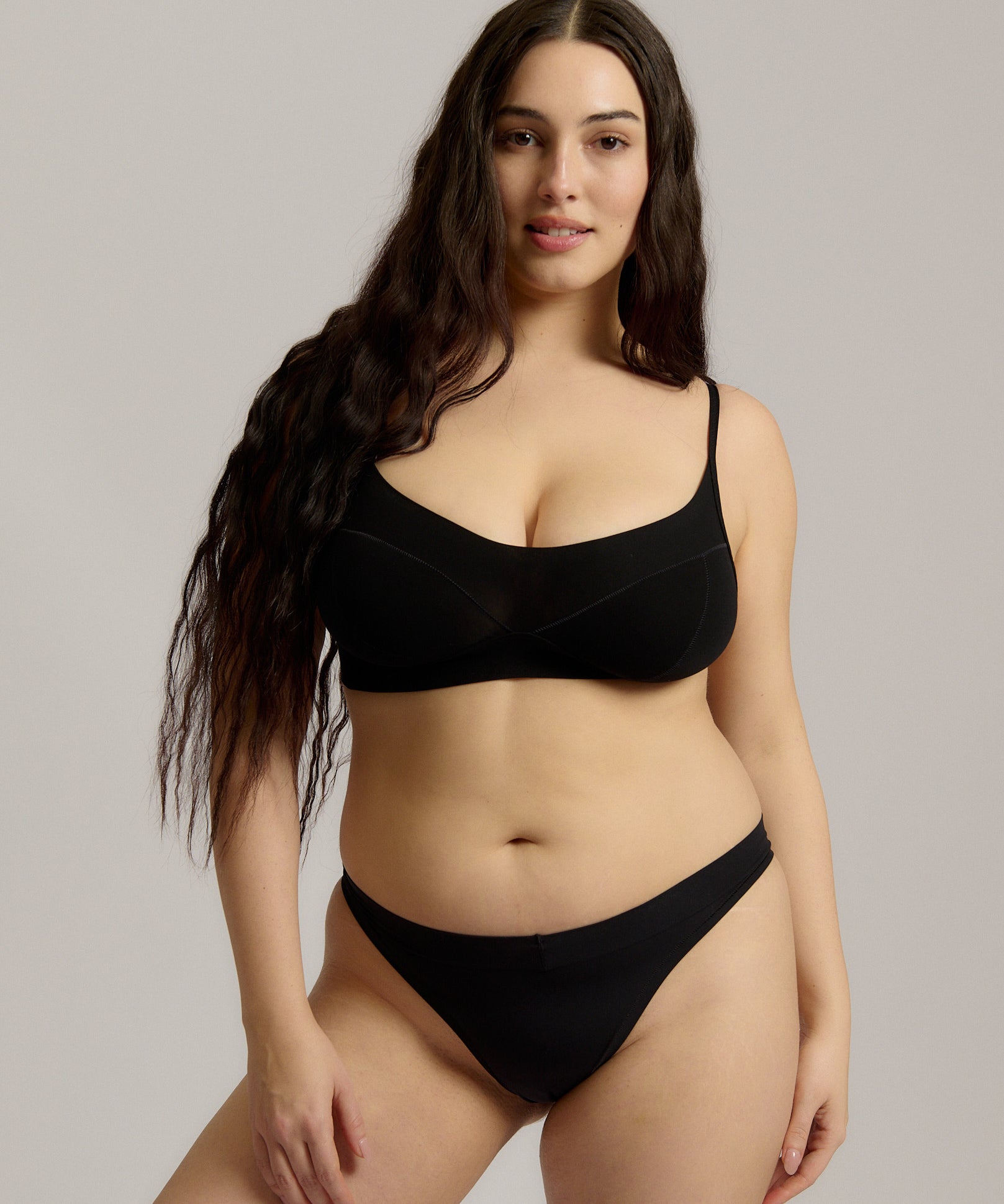 Person wearing a black cami system against a plain background