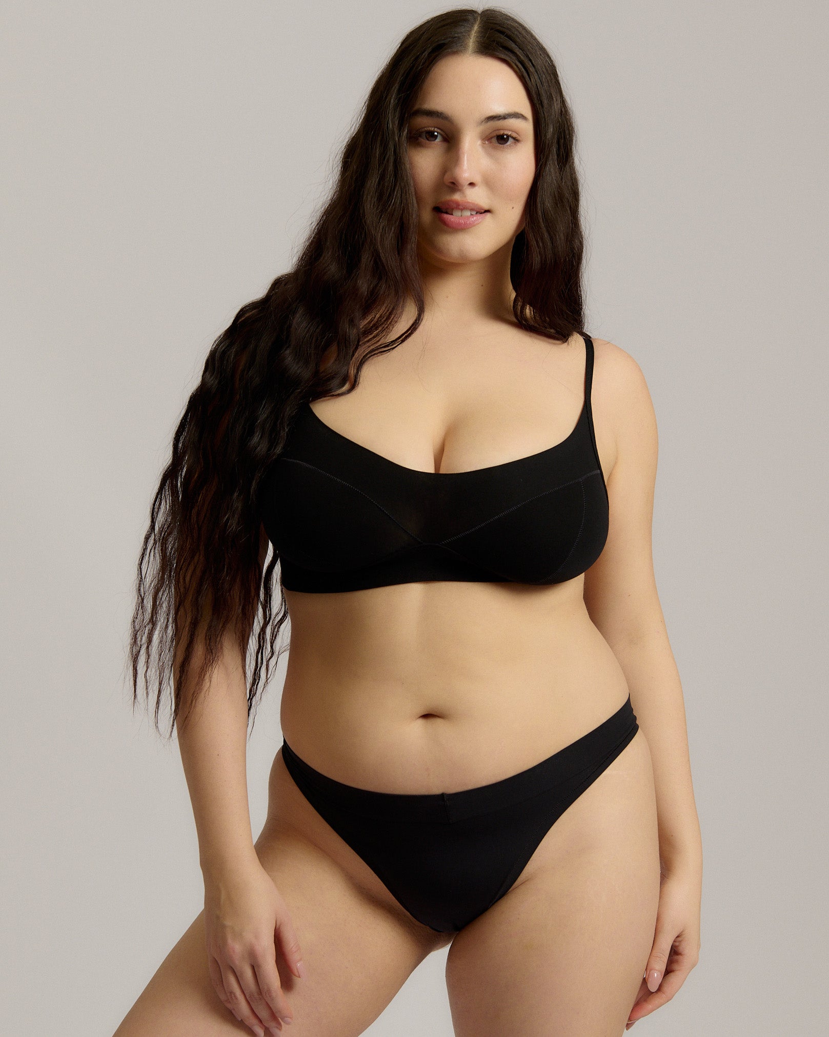 Person wearing a black cami system against a plain background