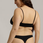 Person wearing a black cami system against a plain background