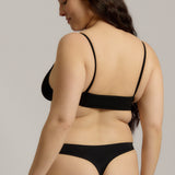 Person wearing a black cami system against a plain background