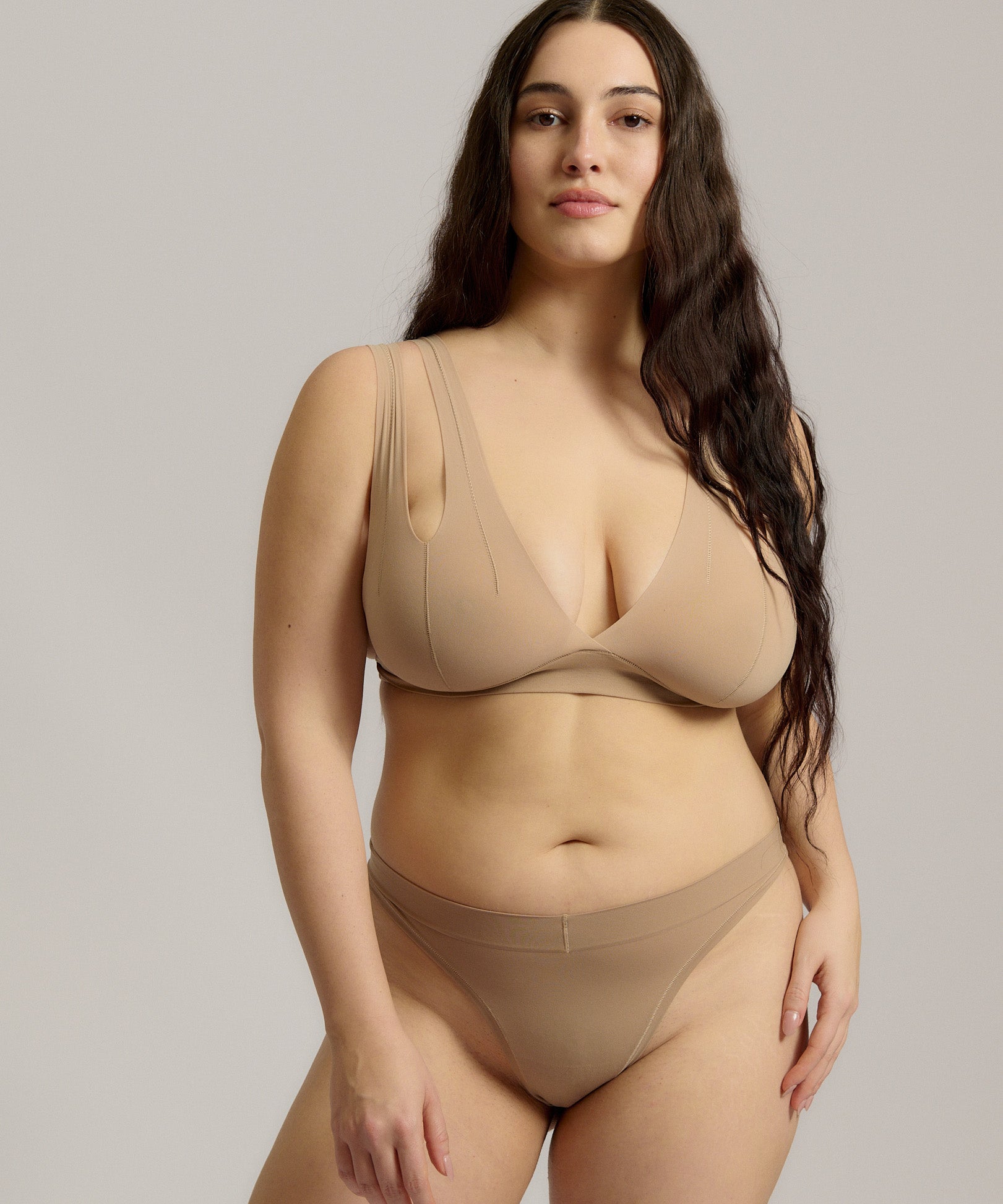 Woman wearing a light tee system against a plain background