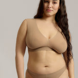 A person wearing a beige fuller coverage bra.