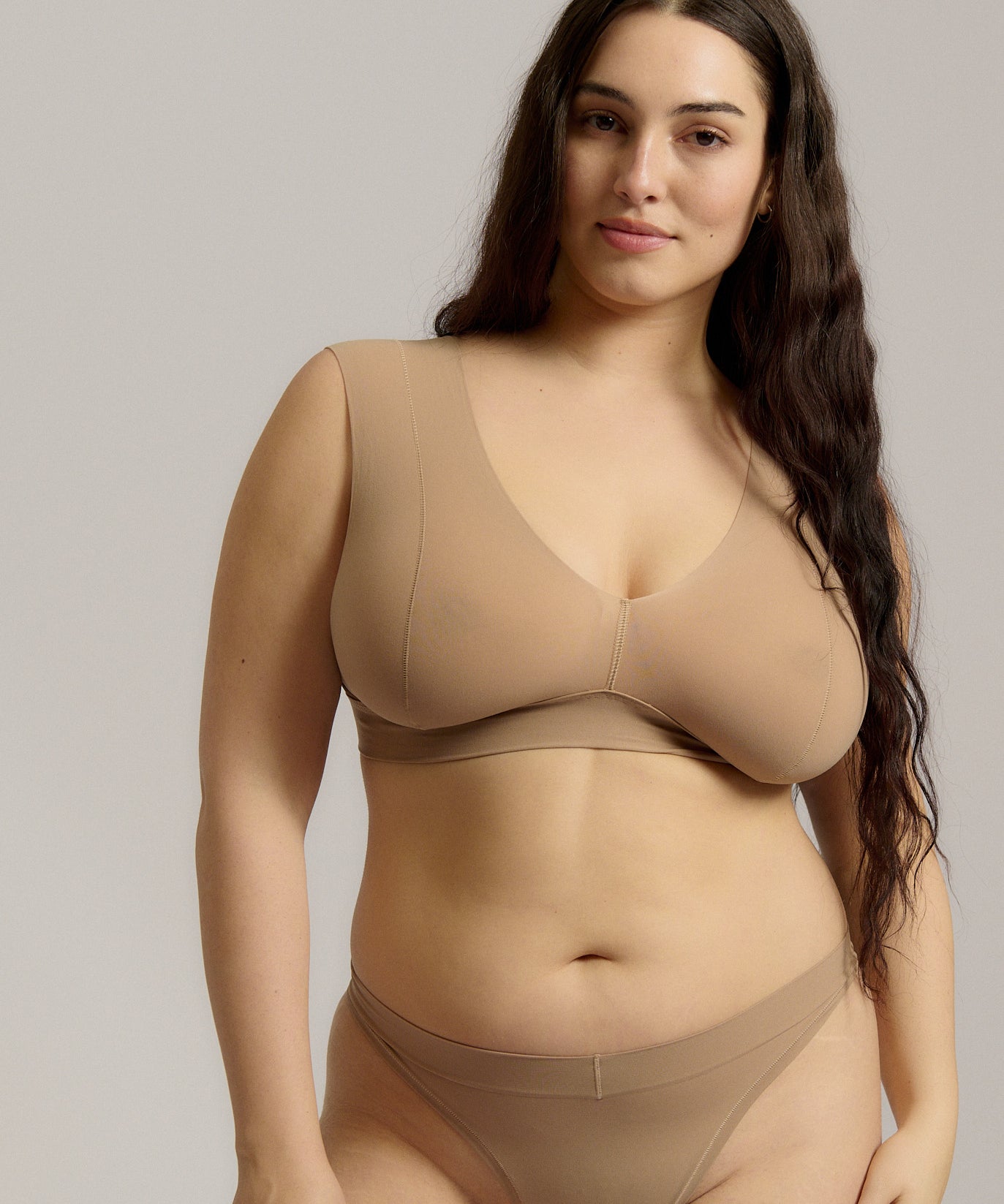 A person wearing a beige fuller coverage bra.