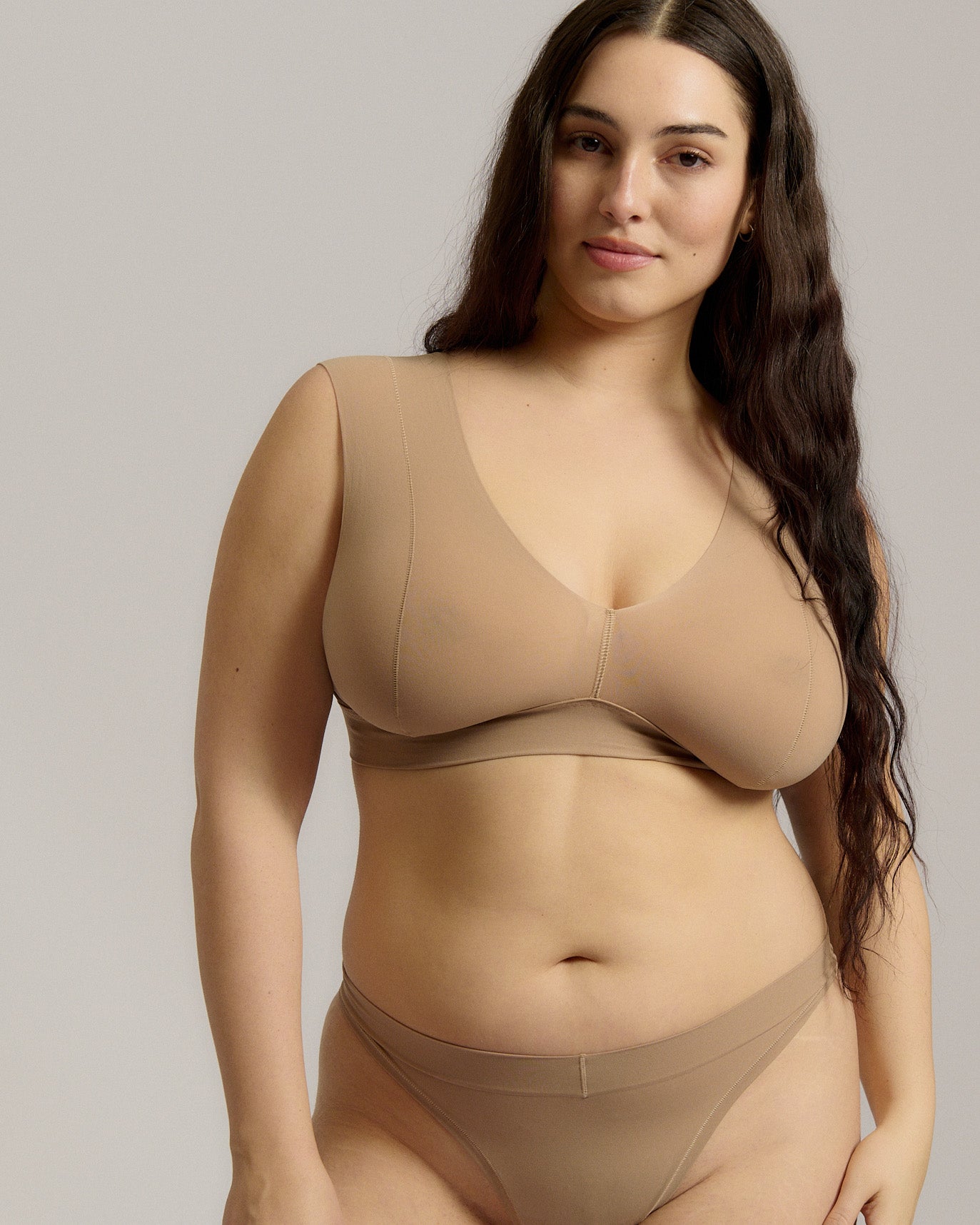 A person wearing a beige fuller coverage bra.