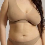 A person wearing a beige fuller coverage bra.