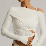 Woman wearing a white wrap top against a plain background