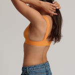 person wearing a tangerine tee system on a plain background