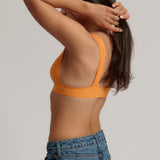 person wearing a tangerine tee system on a plain background