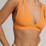 person wearing a tangerine tee system on a plain background