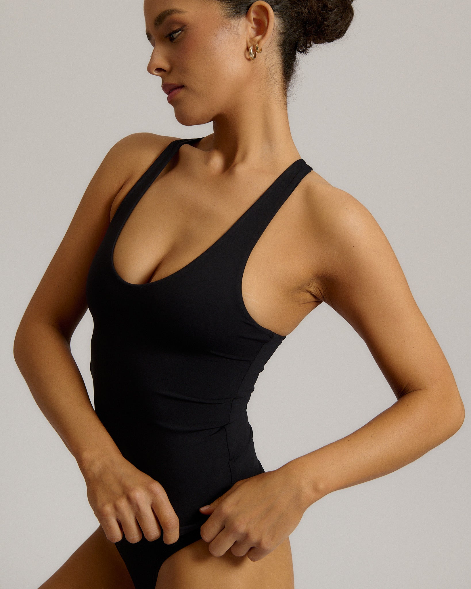 Woman wearing a black racerback against a plain background