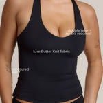 Woman wearing a black racerback against a plain background