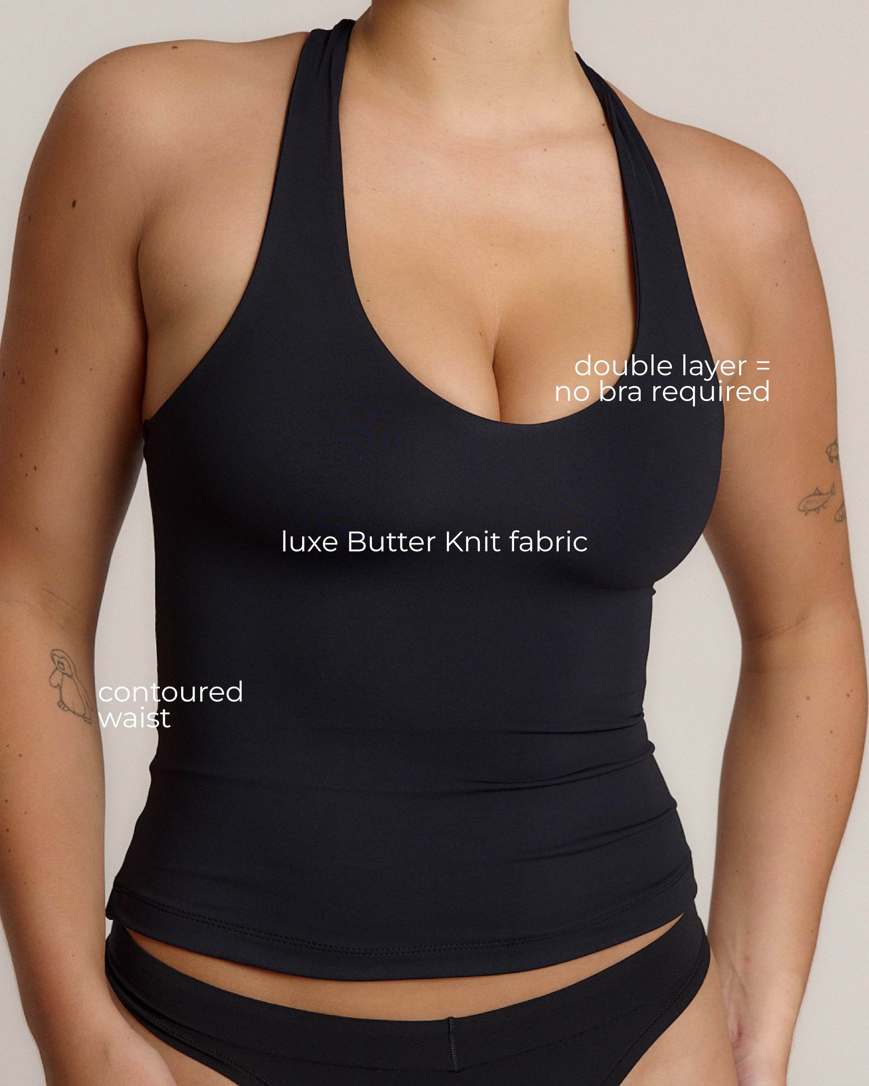 Woman wearing a black racerback against a plain background