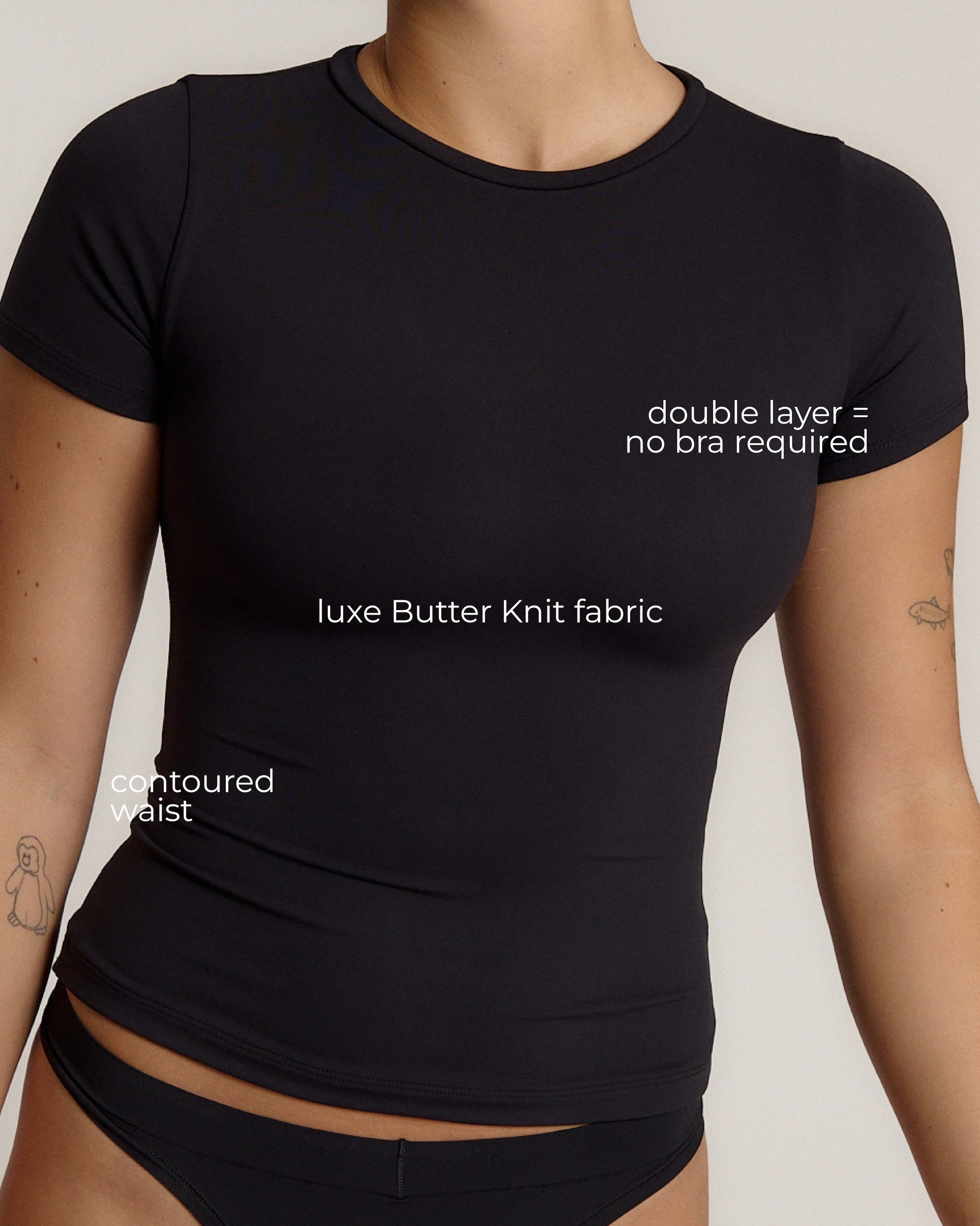 Woman wearing a black t-shirt against a plain background