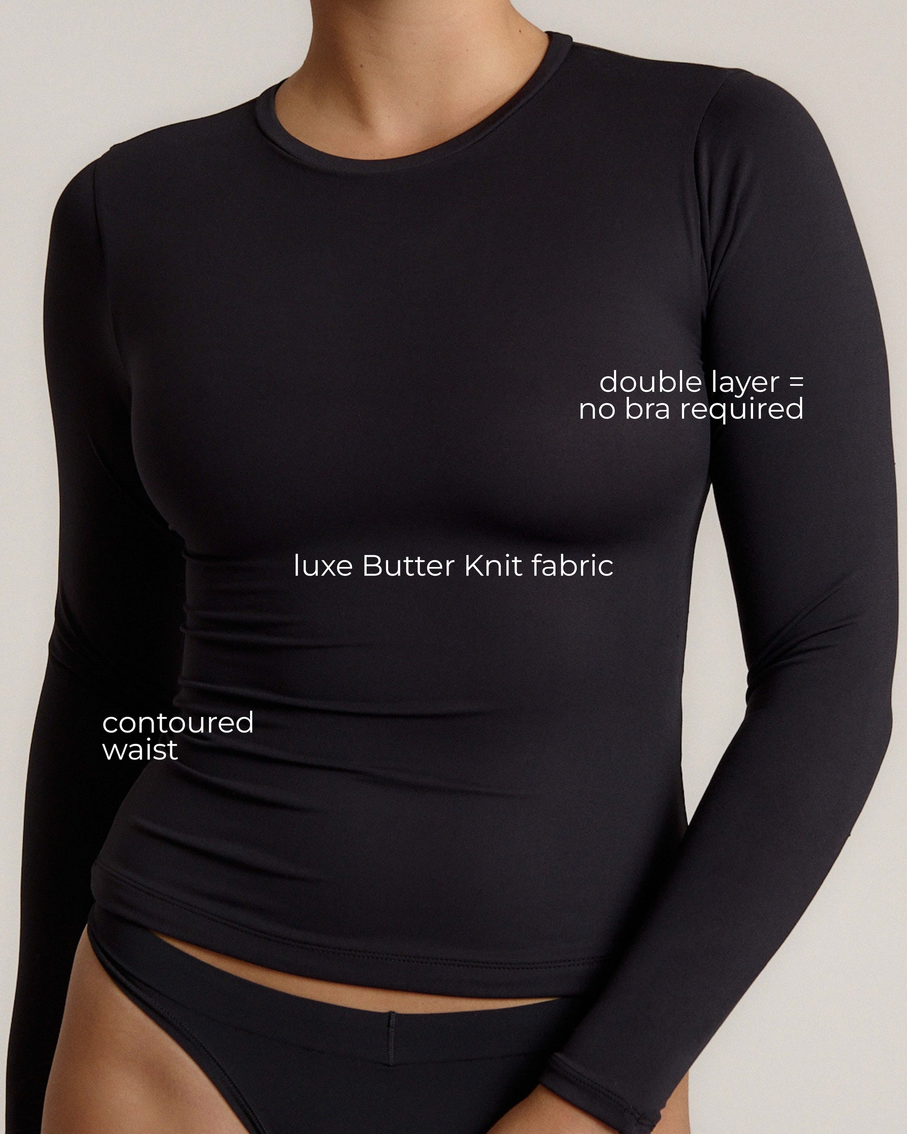 Woman wearing a black long-sleeve top and black bottom on a light gray background