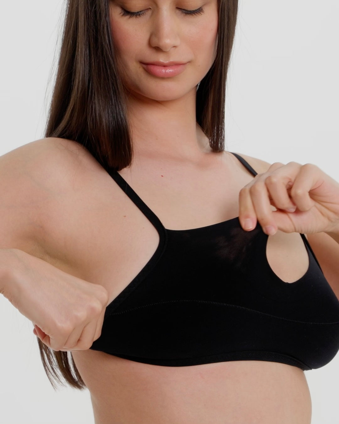 Woman wearing black scoop system against a neutral background
