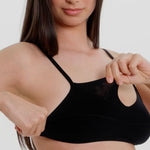 Woman wearing black scoop system against a neutral background