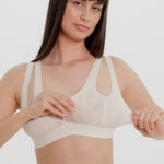 A person wearing a white, solid-colored bra and matching thong, with unique strap details and a v-neckline.