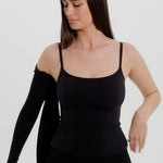 Person wearing a black bra and bolero on a plain background