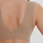 A person wearing a beige fuller coverage bra.