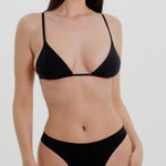 Black triangle bra worn by a model on a plain background