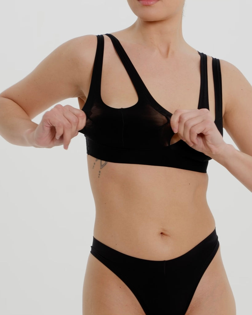 Woman wearing black tee system on plain background