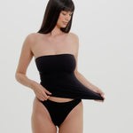 A person wearing a black tube top on a plain background