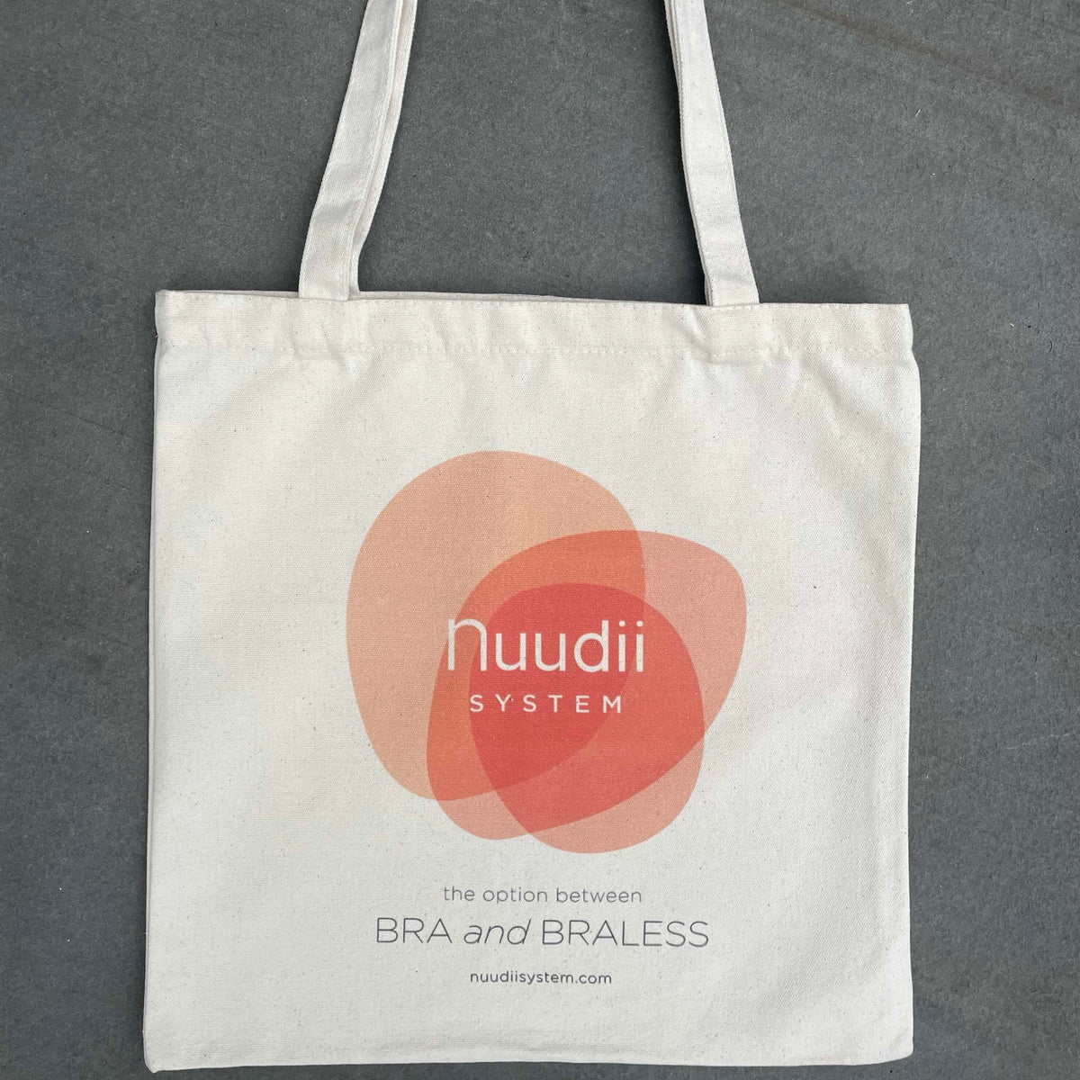 Front of tote bag with Nuudii System logo and The Option Between Bra and Braless